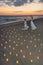 Couple at sea beach in candles against sunset