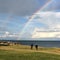 Couple by sea watching rainbow.