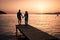 couple seated on a wooden jetty, looking a colorful sunset on the sea , men and woman watching sunset in Crete Greece