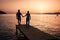 couple seated on a wooden jetty, looking a colorful sunset on the sea , men and woman watching sunset in Crete Greece