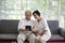 Couple of seniors smiling and looking at the same tablet on the sofa. Mature couple making a selfie or video call