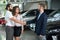 Couple shaking hands with car dealer, buying automobile.