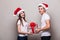 Couple share christmas gift on grey background