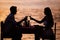 Couple sharing romantic sunset dinner on the beach