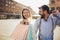 Couple with shopping bags is talking and smiling while doing shopping in the city