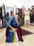 Couple shopping with man tired and bored holding bags and woman happy looking for dress