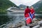 Couple on the shore of the fjord looks at a cruise liner, Norway