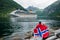 Couple on the shore of the fjord looks at a cruise liner, Norway