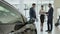 The couple signs the contract of buying car in the car showroom and gets key