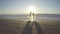 Couple silhouette playing in the sea and kissing on a beach at sunrise