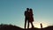 Couple silhouette walking. slow motion video. holding hand toward the sun outdoors at sunset dramatic sky background and