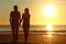 Couple silhouette walking together on the beach