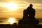 Couple silhouette watching sunset on the beach