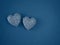 Couple of silver handmade soap in the shape of hearts on a blue background top view with copy space.