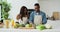 Couple singing and dancing while making salad in kitchen