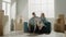 Couple sits on blue couch and discusses wall renovation