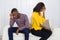 Couple Sitting Back To Back On Sofa