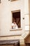 Couple sitting on the bedroom window of an apartment in the French court