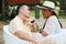 Couple sitting on a bench confidant chairs in Merida in Yucatan Mexico show their love with flirtatious looks and kisses