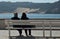 Couple sitting on a bench and watching the Concha of Sao Martinho, Centro - Portugal