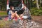 couple sitting on blanket near bonfire white suv vehicle on background