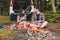 couple sitting on blanket near bonfire white suv vehicle on background