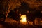 Couple sitting at burning camp fire in the night. Camping in the forest under starry sky, Namibia, Africa. Summer adventures and e