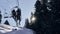 Couple sitting on a cable car at Alpe d Huez ski resort with trees and blue sky