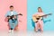 couple sitting on chairs, playing electric and acoustic guitars while looking at camera