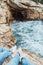 couple sitting at cliff looking at storming sea near grotto