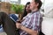 Couple sitting floor apartment looking at laptop