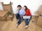 couple sitting on floor moving in a new house or apartment flat