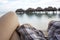 Couple sitting on Hammock looking over the beach and overwater huts