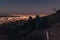 Couple sitting on a hilltop looking at the cityscape below