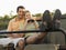 Couple Sitting In Jeep With Binoculars