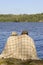 Couple sitting by a lakeside with blanket around shoulders.