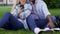 Couple sitting on lawn closely and looking at mobile phone of girl, gadgets