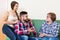 Couple sitting in living room and talking with mother