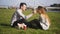 Couple sitting in the park on grass, laughing, talking, smiling. The man takes care of the girl, removes the hair from her face.