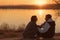 Couple sitting sunset lake