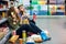 Couple sitting on the supermarket floor and eating snacks