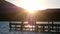 A couple sitting on the wooden jetty. Sunset scene at the lake