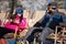 Couple skiers relax in chairs on the mountain top