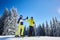 Couple of skiers on skis on hill at ski resort. Recreational activities in mountains concept. Low angle full-length shot