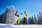 Couple of skiers on skis on hill at ski resort. Recreational activities in mountains concept. Low angle full-length shot