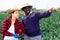 Couple of skilled workers man and woman working on farm field