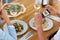 Couple with smartphone photographing food at cafe