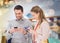 Couple with smartphones and shopping bags in mall