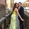 Couple smiles while their pose on the wooden bridge