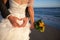 Couple smiling and embracing near wedding arch on beach. Honeymoon on sea or ocean